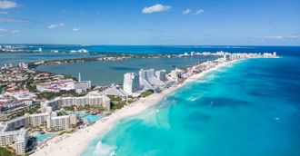 Un grupo de personas juega al frisbee en la playa.