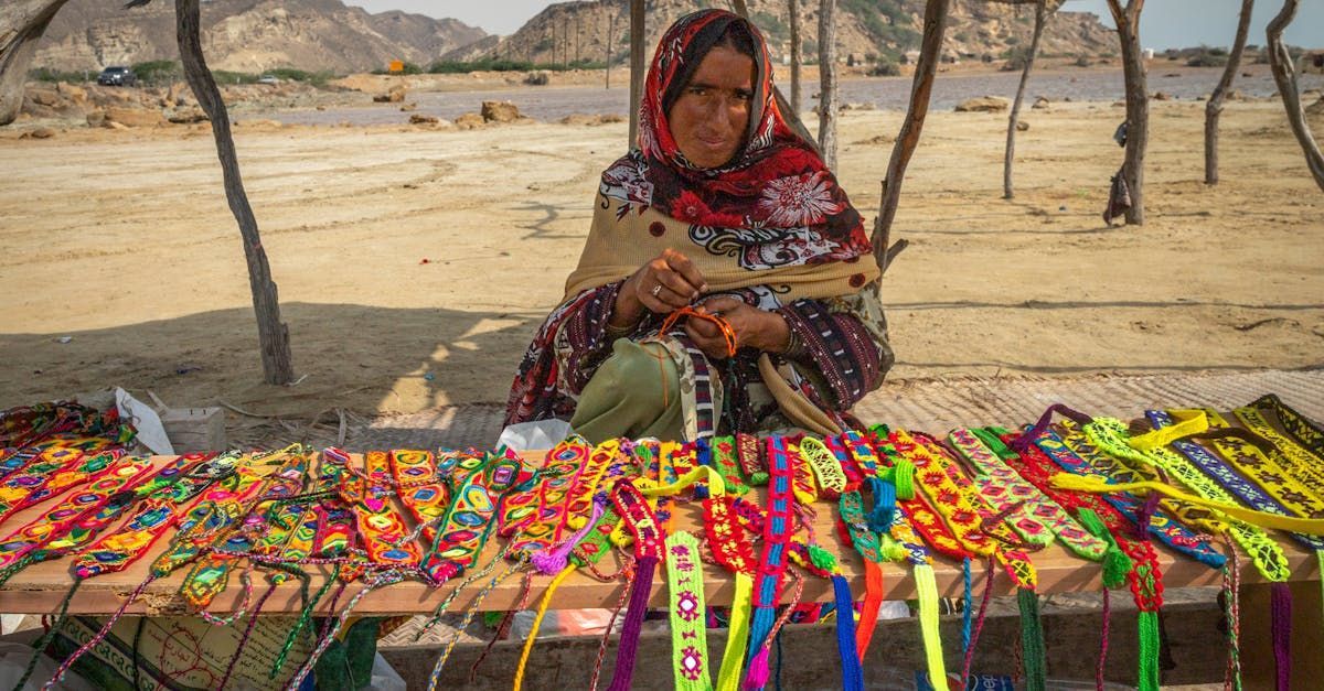 A woman is sitting at a table selling bracelets.