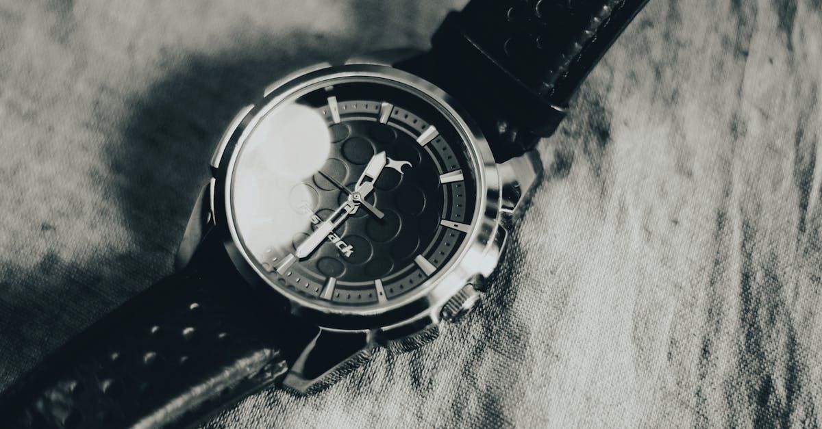A black and white photo of a watch on a table.