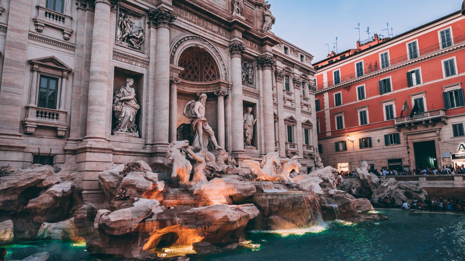 Trevi Fountain illuminated at night in Rome, showcasing intricate sculptures and flowing water