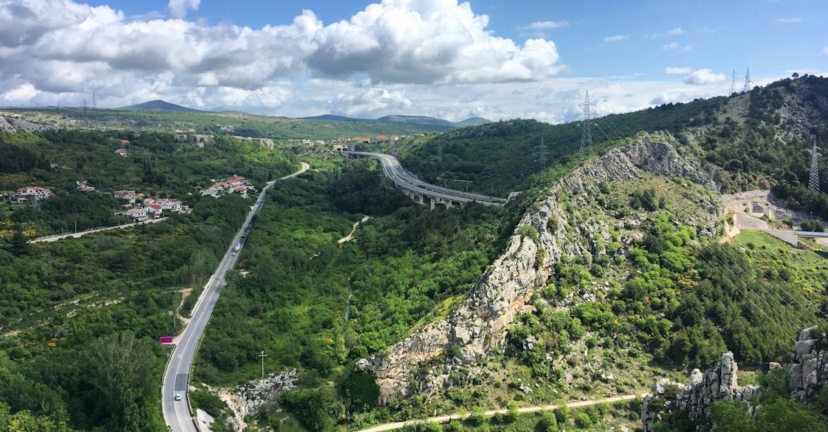 An aerial view of a mountain valley with a road going through it.