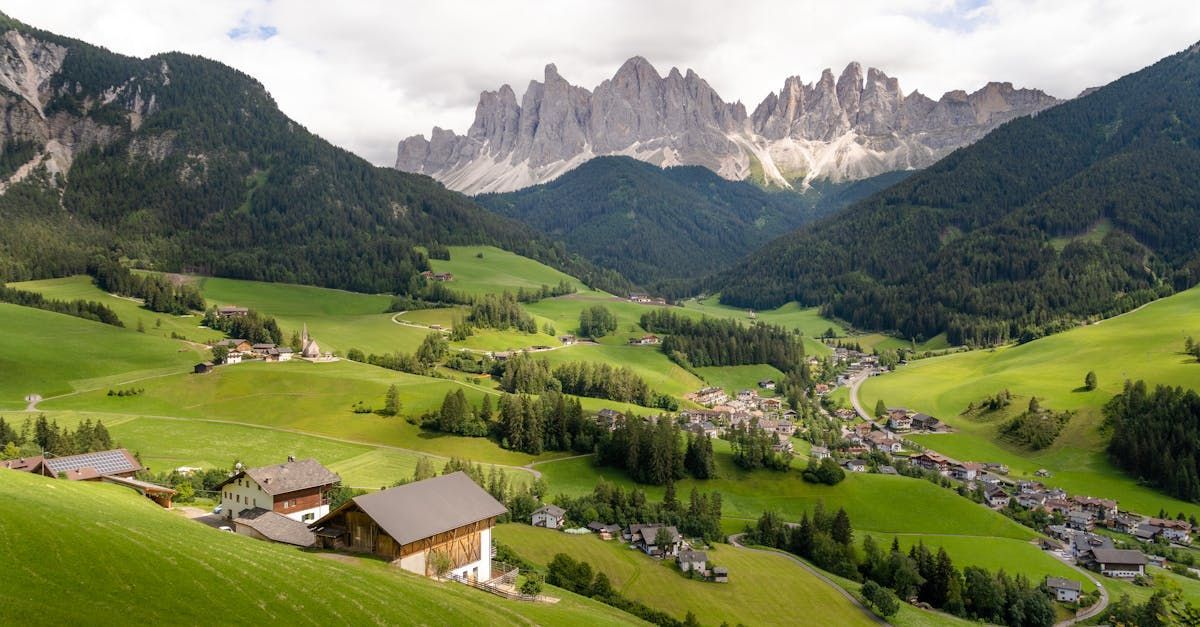 A village in the middle of a valley with mountains in the background