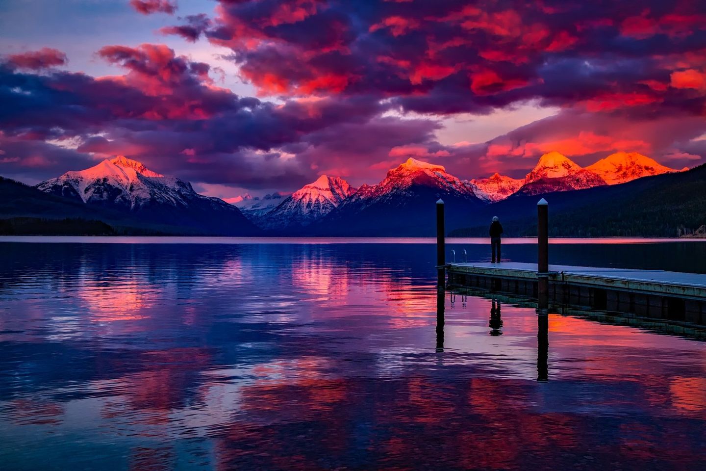 A sunset over a lake with mountains in the background