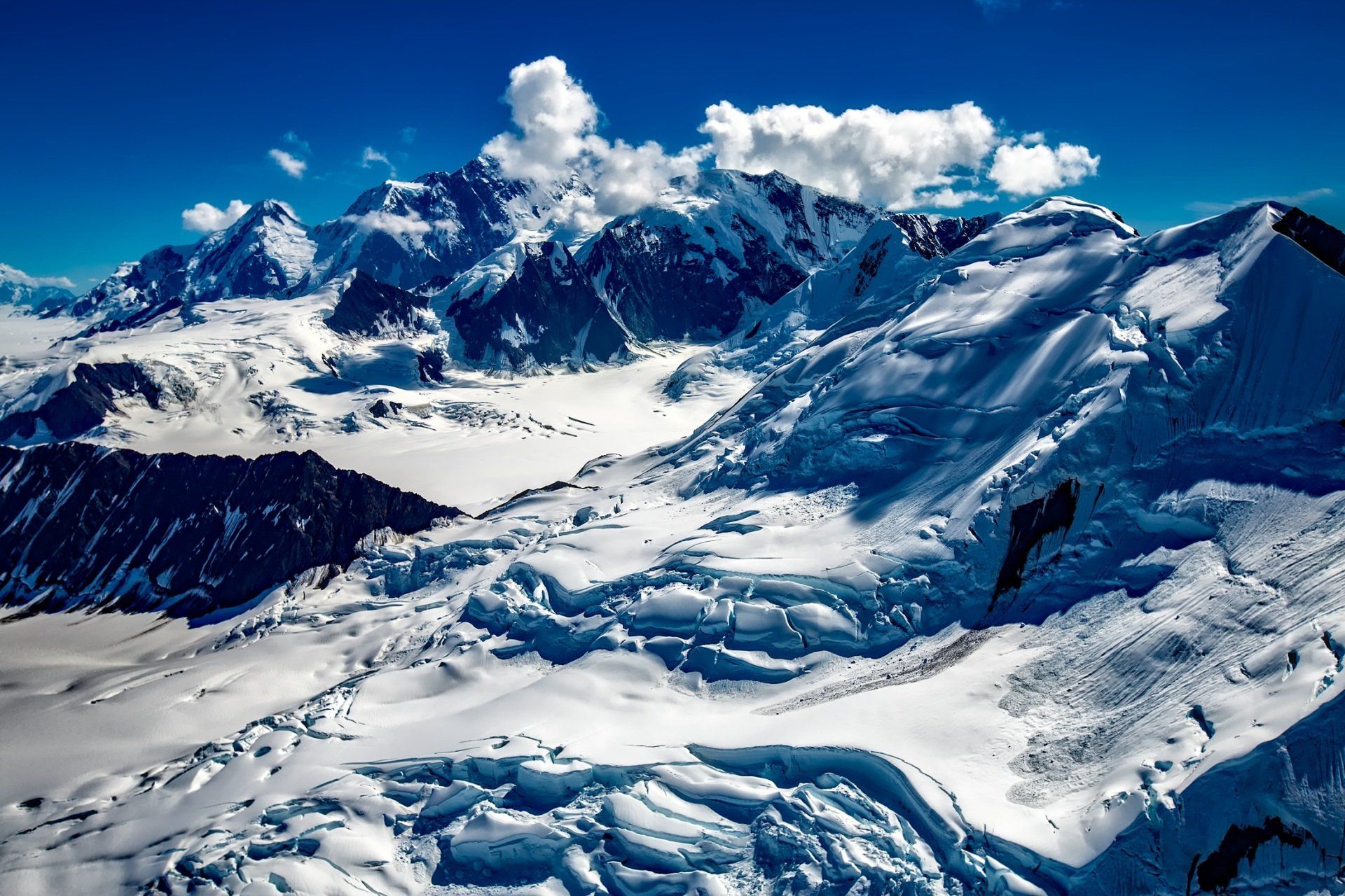a snowy mountain with a blue sky in the background