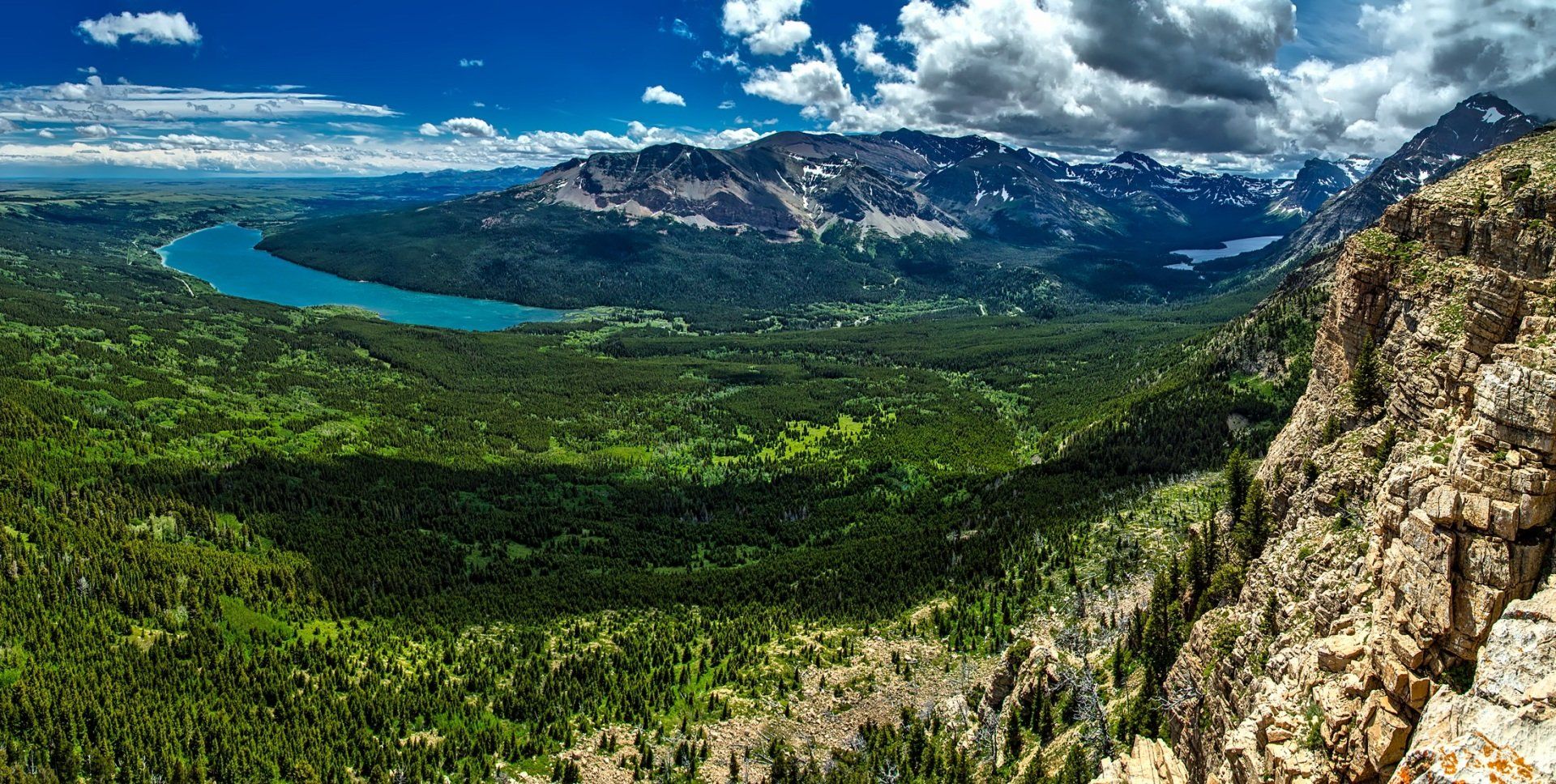 An aerial view of a lake surrounded by mountains and trees.