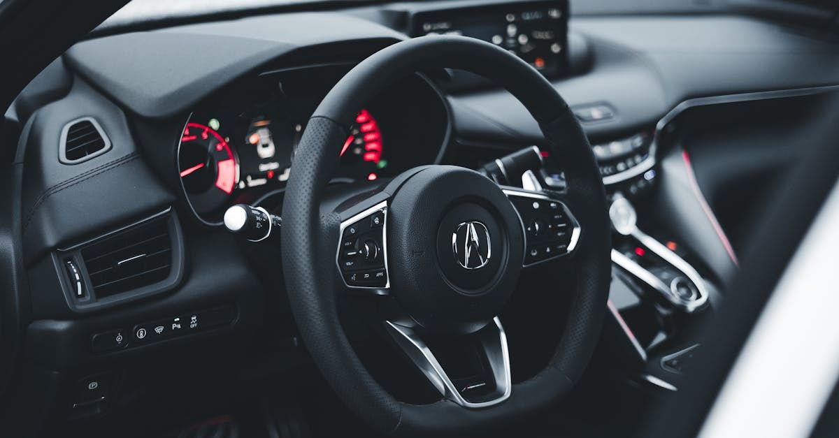 The inside of a car with a steering wheel and dashboard.