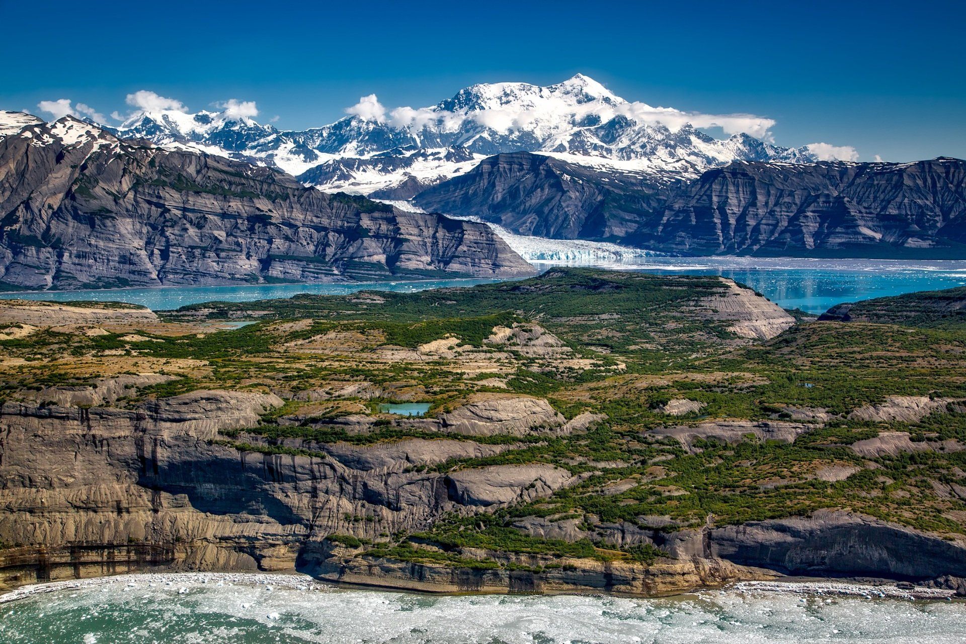 a landscape with mountains and a lake in the foreground and a glacier in the background .