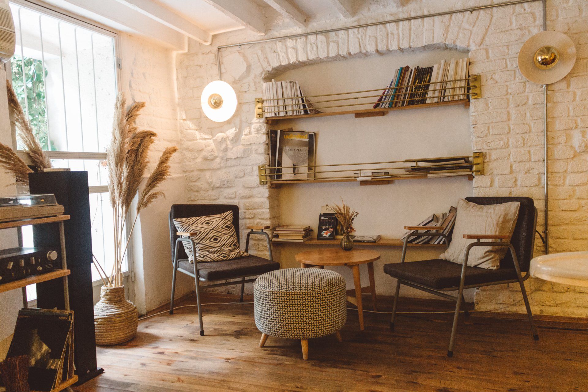 A living room filled with furniture and a brick wall.