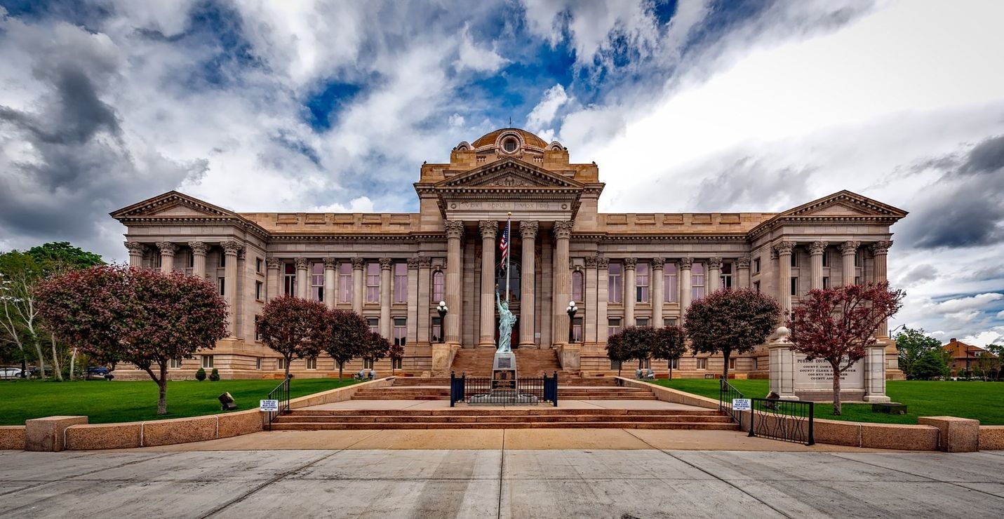 A large building with columns and trees in front of it