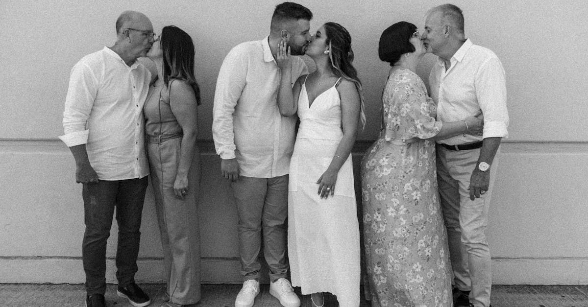 A black and white photo of a bride and groom kissing while standing next to each other.