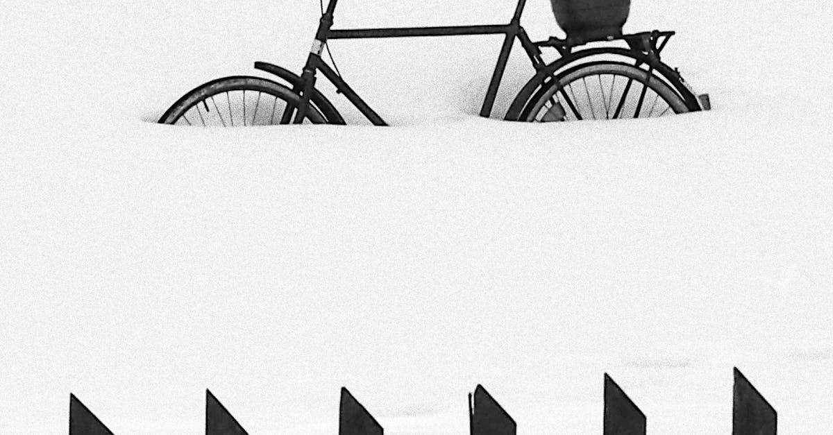 A black and white photo of a bicycle in the snow