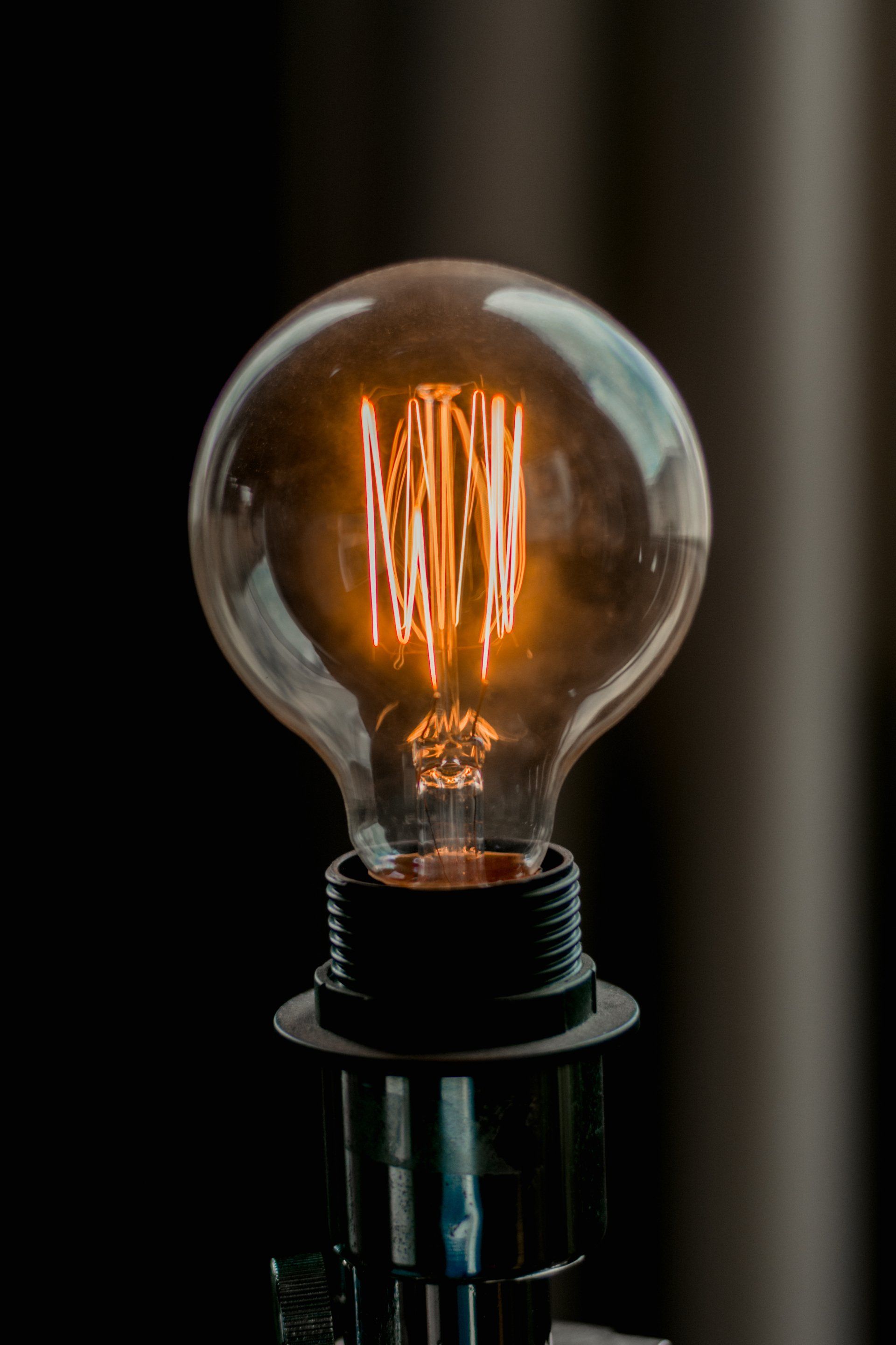 A close up of a light bulb sitting on top of a lamp.