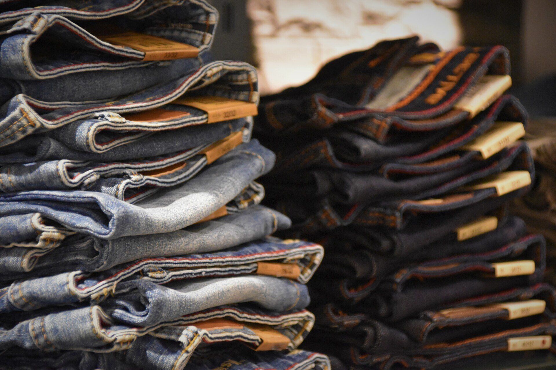 A stack of jeans is sitting on top of each other on a table.