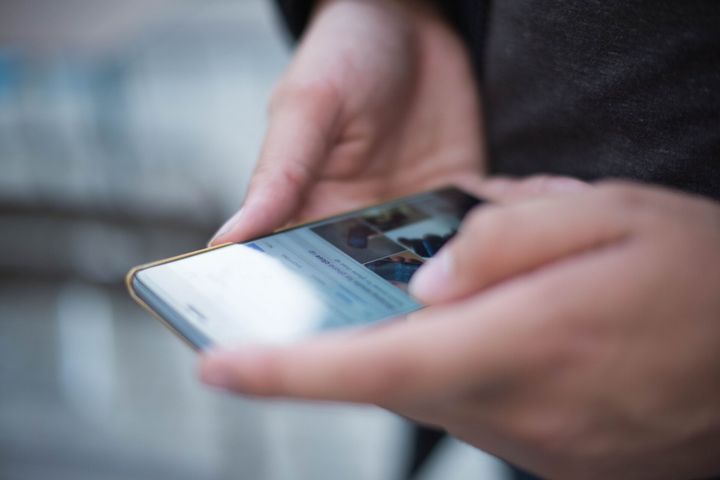 Uma pessoa está segurando um telefone celular nas mãos