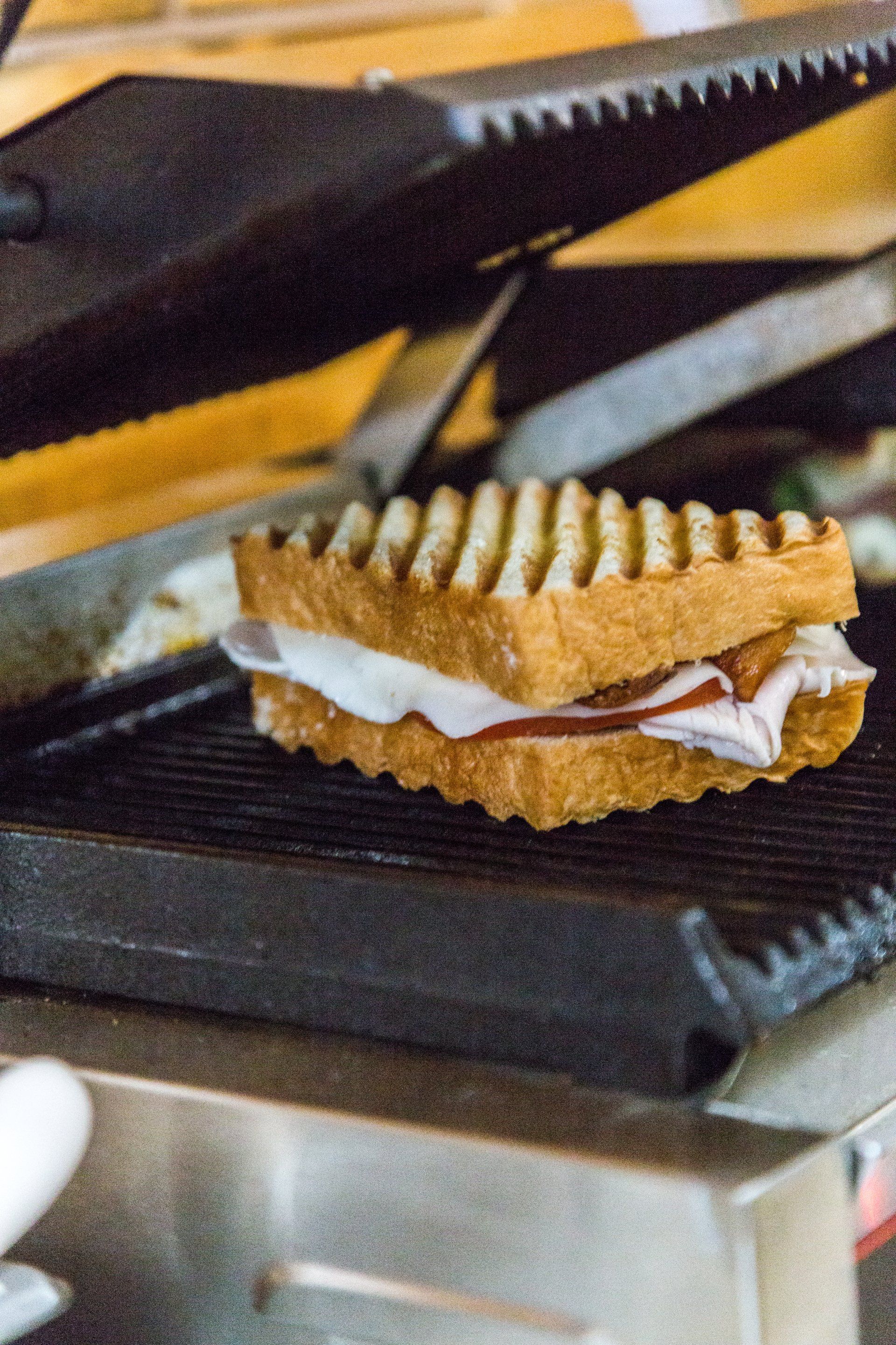 A sandwich is being cooked on a grill.