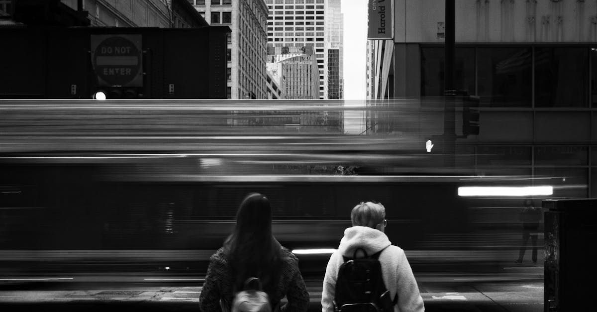 A black and white photo of two people standing next to each other in front of a train.