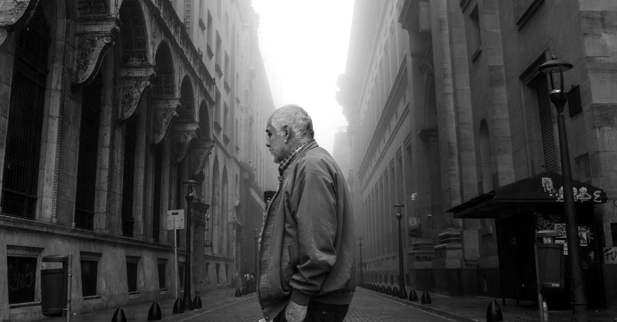 A black and white photo of a man walking down a city street.