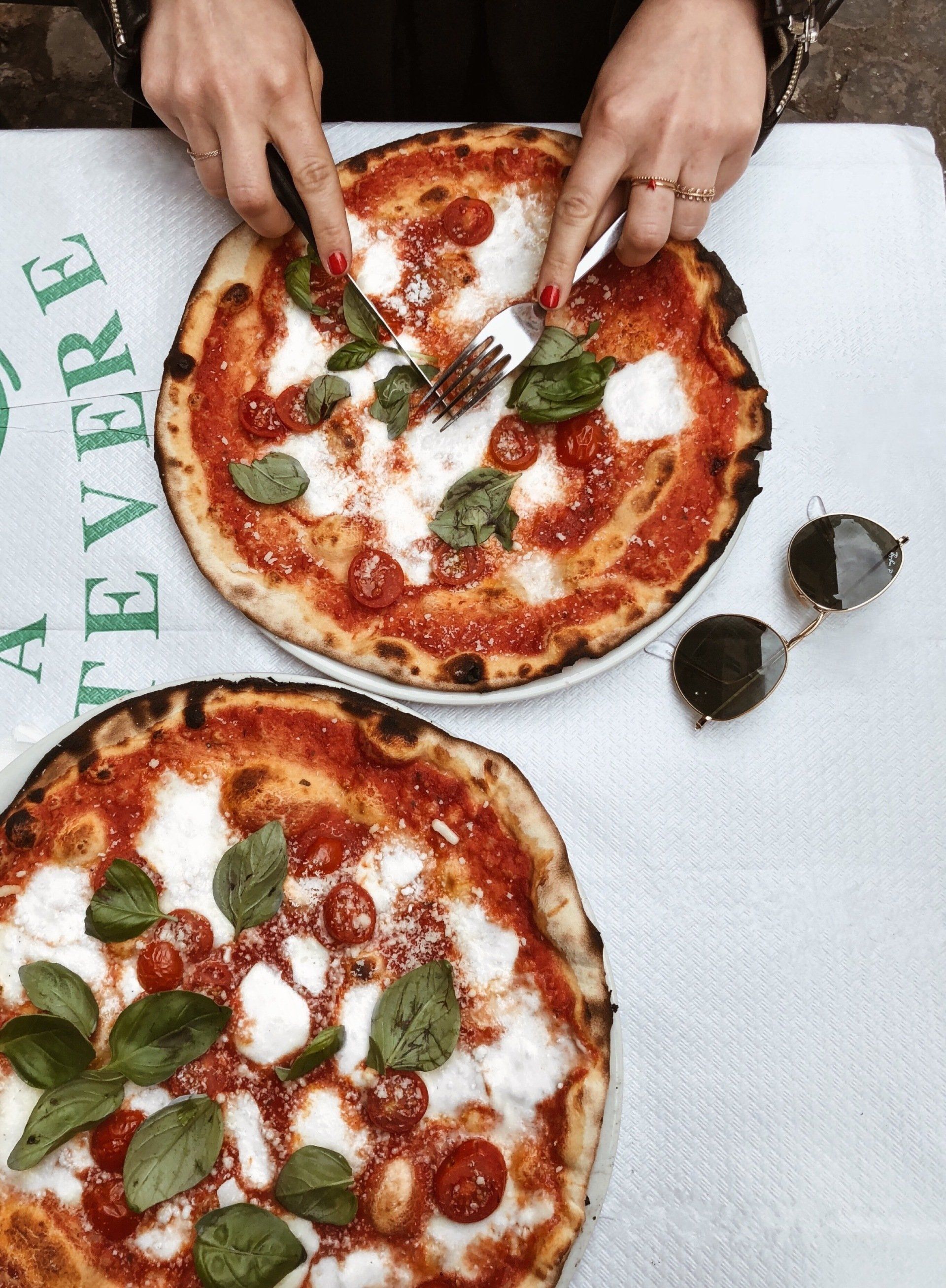 Two wood fired Margherita pizzas on a table
