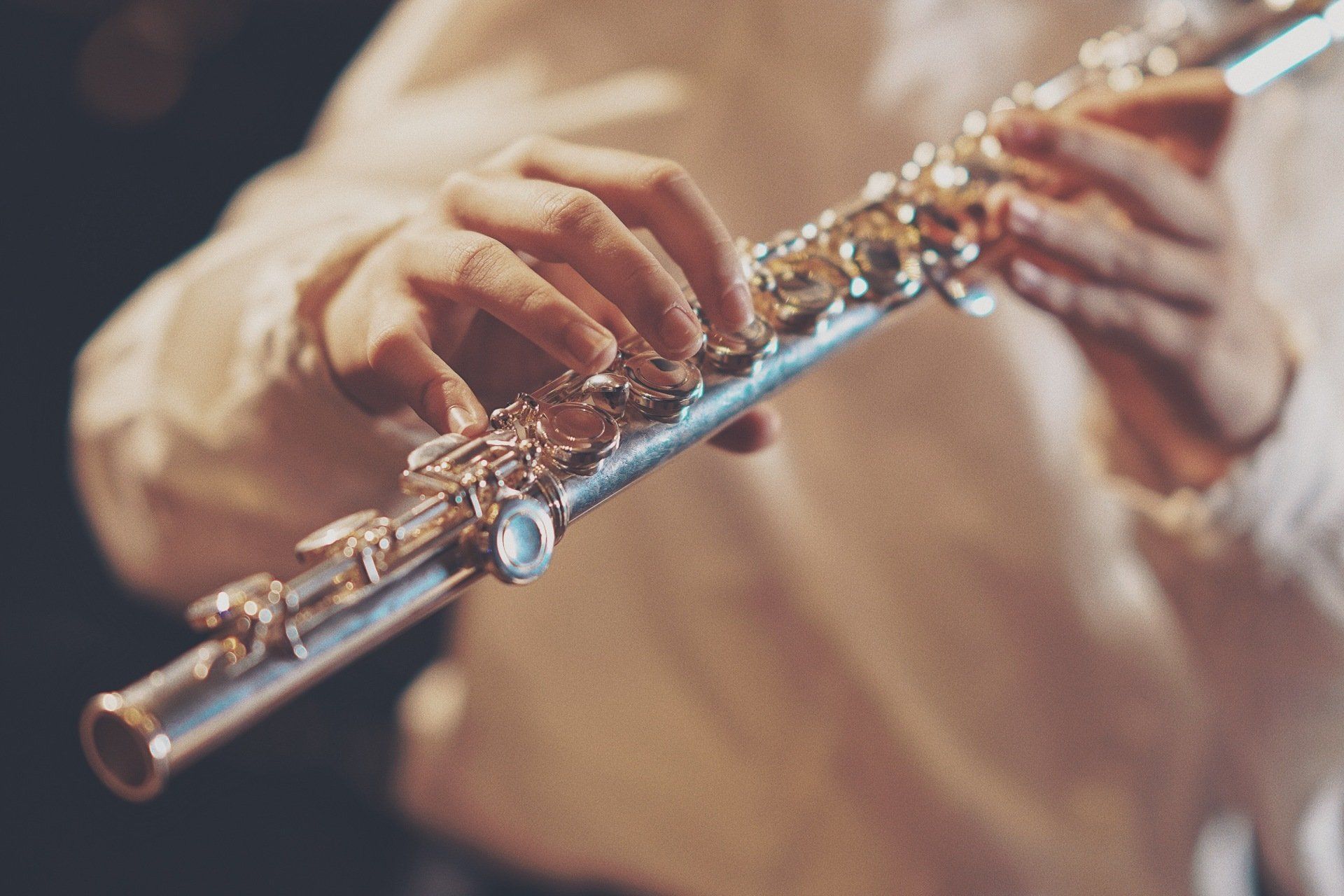 a person is playing a flute with their hands .