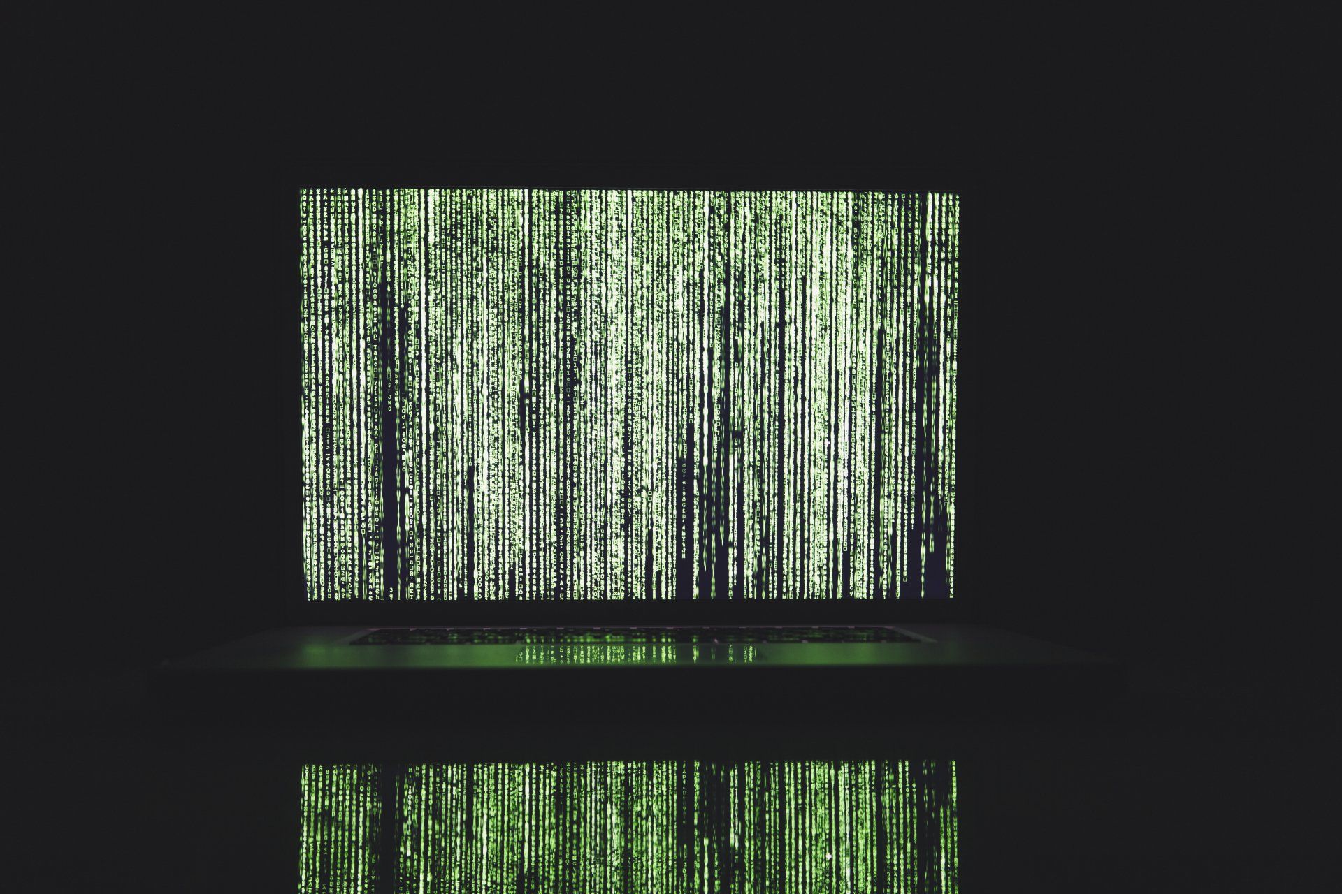 A laptop computer with a green matrix background on the screen.