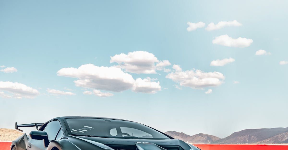 A sports car is parked in the desert with mountains in the background