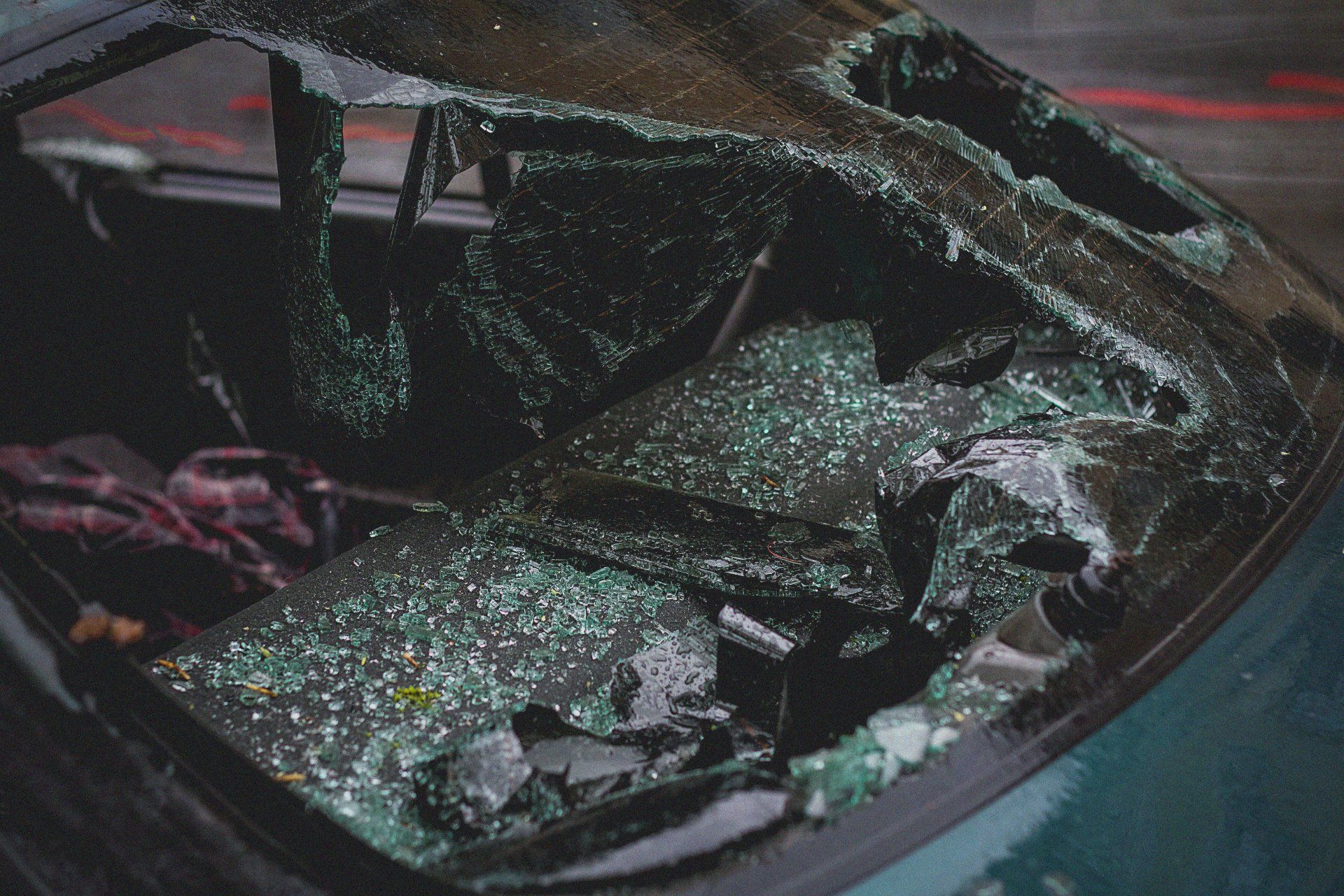 A car with a broken windshield is sitting on the street