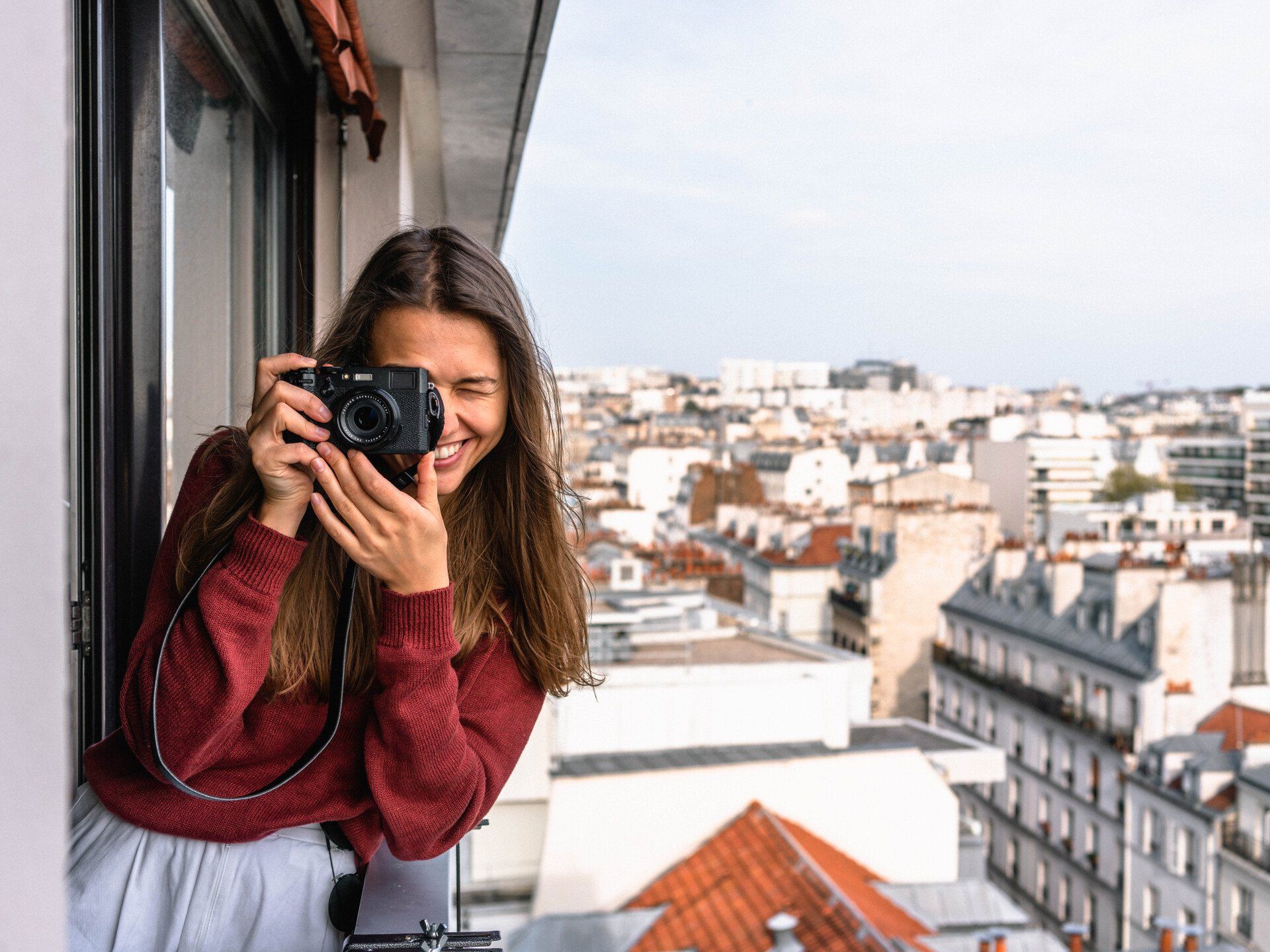 Una mujer está tomando una fotografía de una ciudad con una cámara.