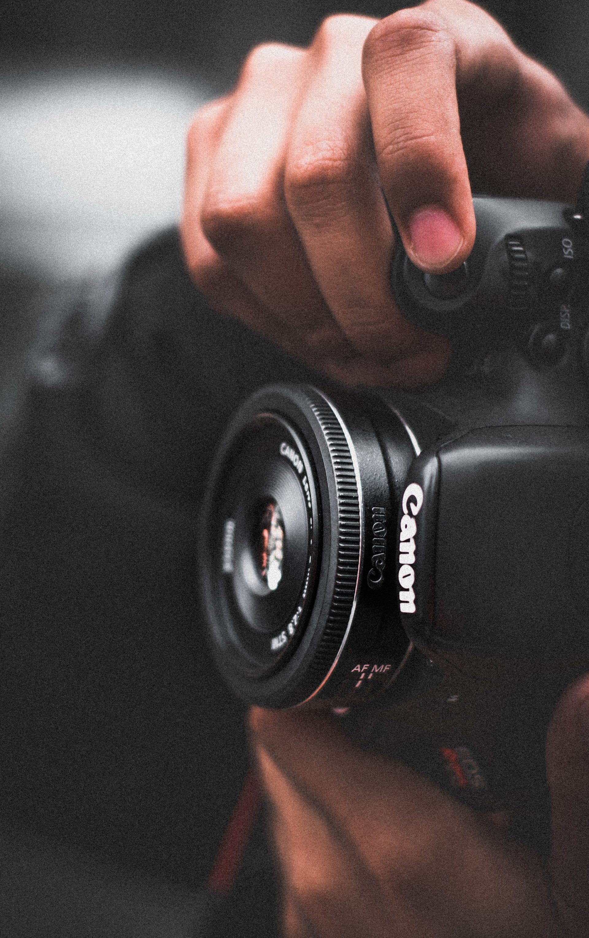une personne tient un appareil photo canon dans ses mains