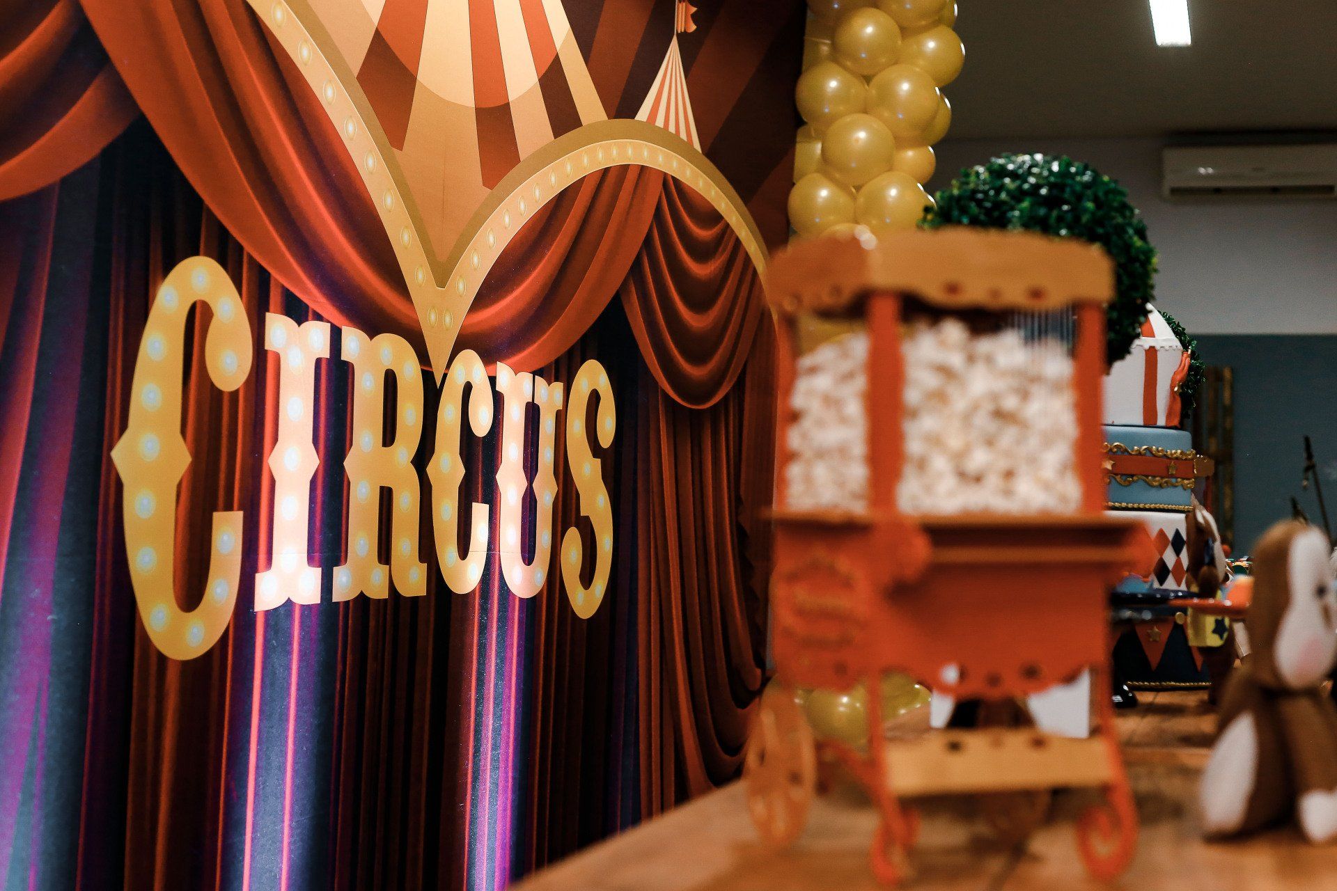 A circus sign with a popcorn cart in front of it
