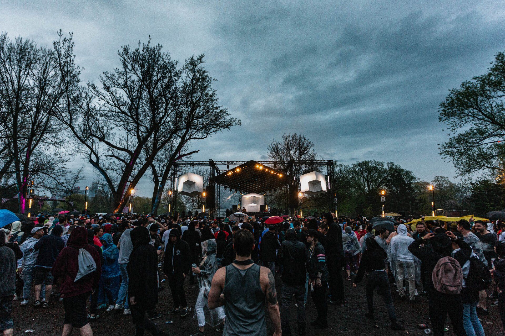 A crowd of people are standing in front of a stage at a concert.