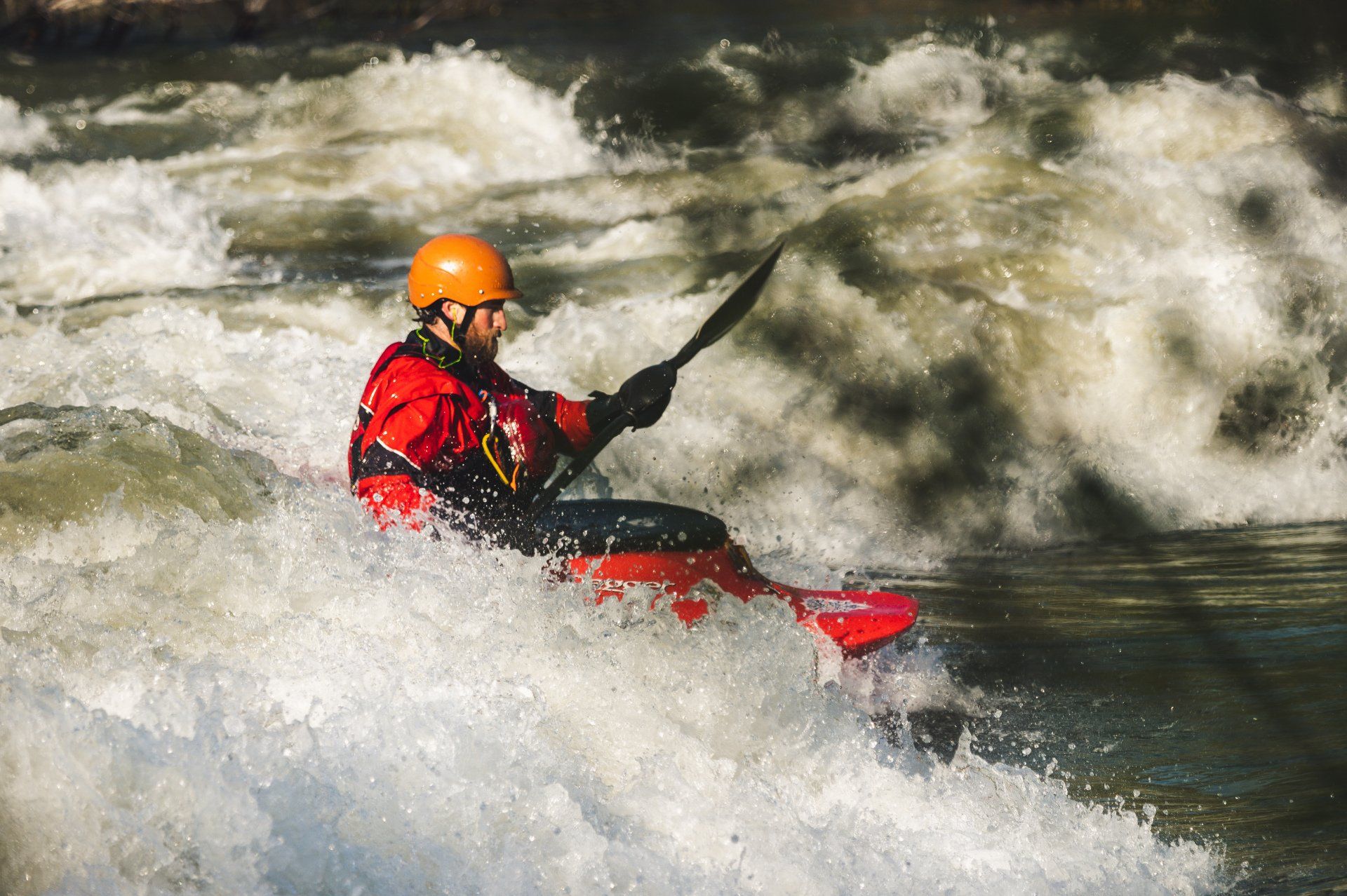 A person is riding a kayak down a river.