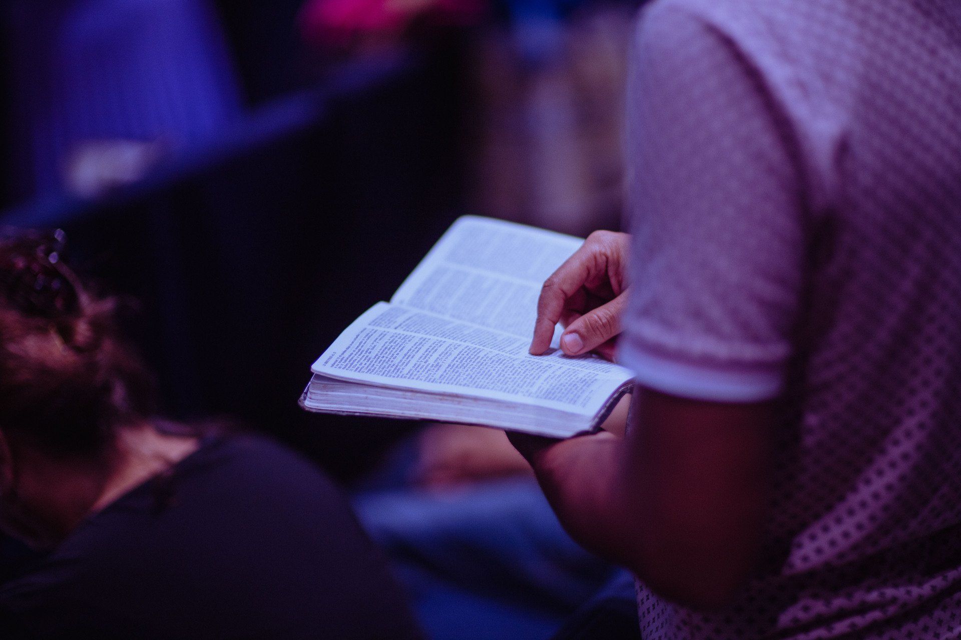 a person is holding a bible in their hand .