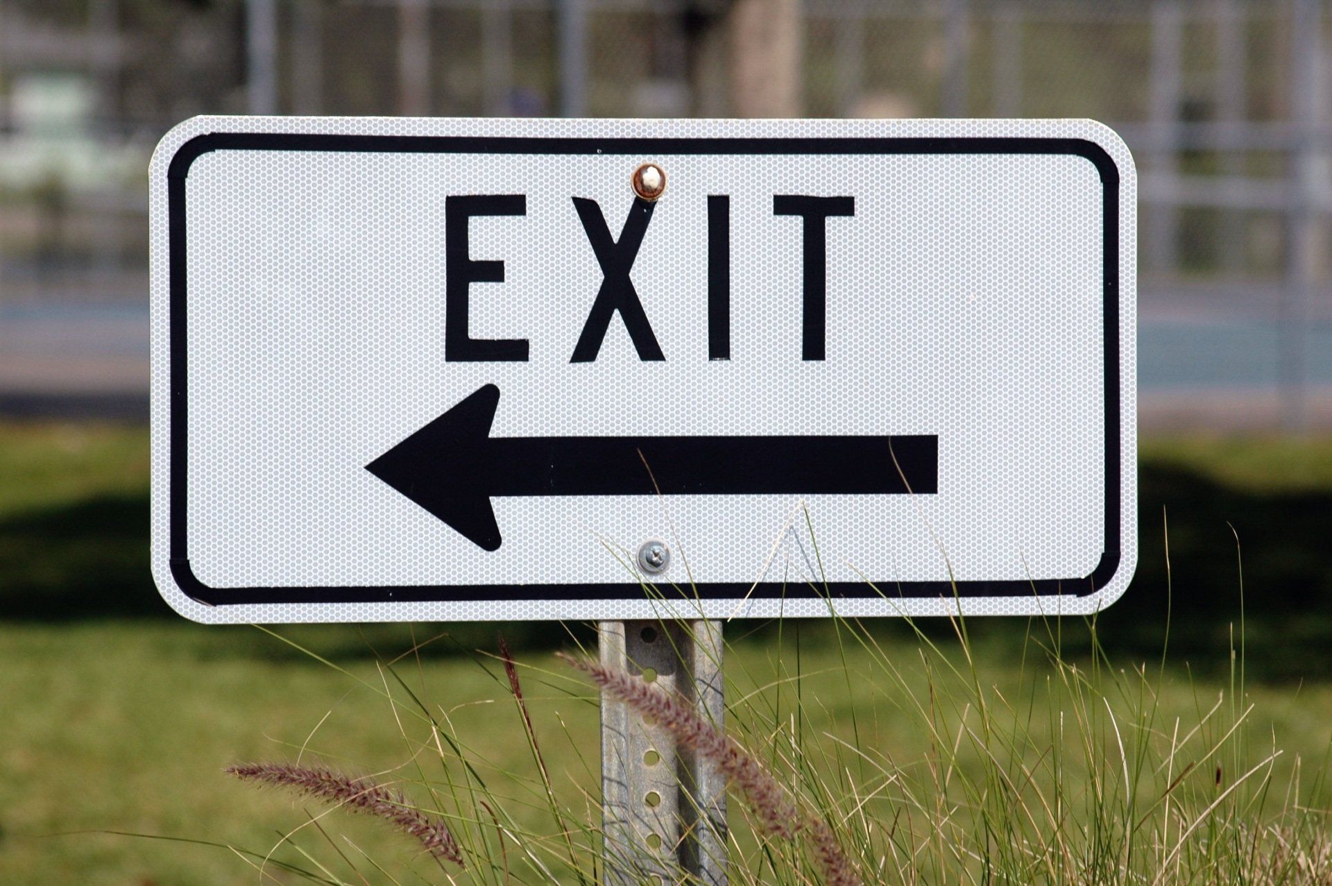 a white exit sign with an arrow pointing to the right .