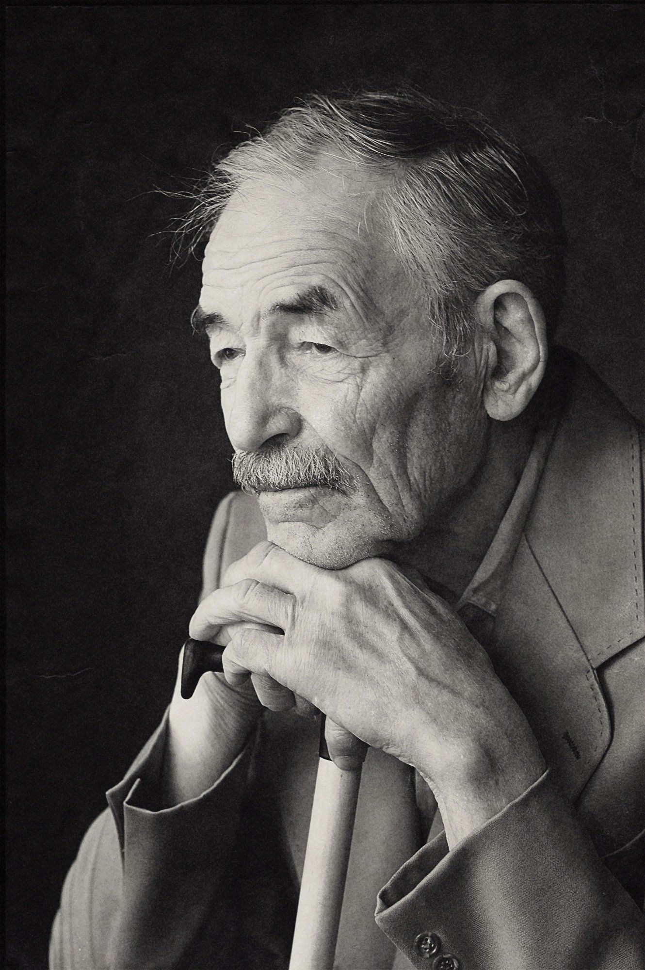 A black and white photo of an older man with a cane