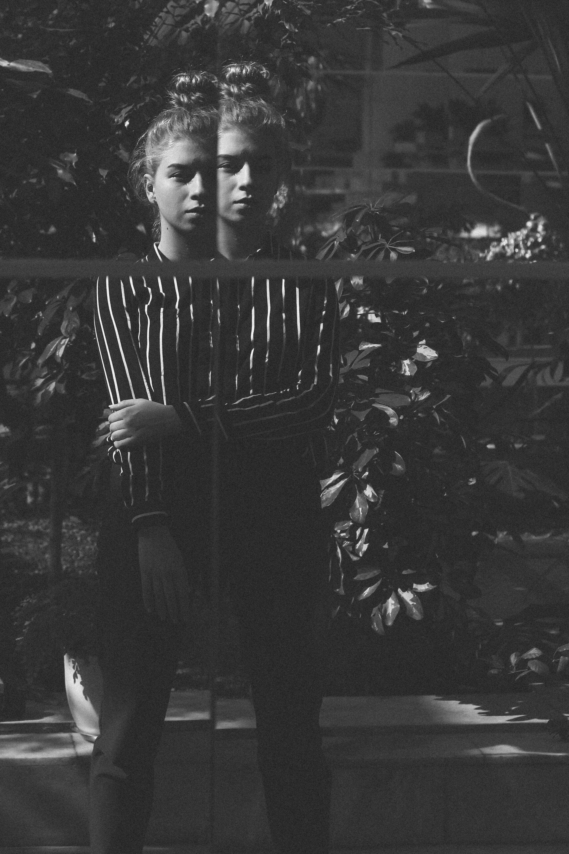 A black and white photo of two girls standing next to each other.