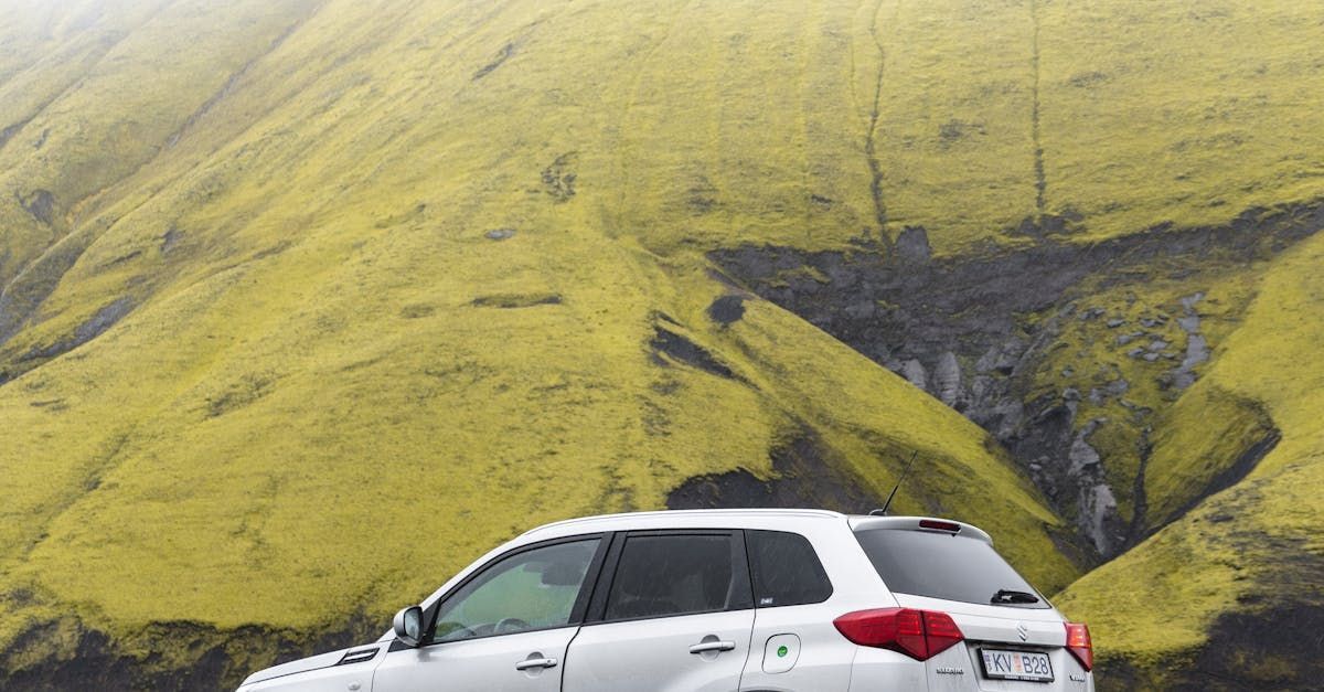 A white SUV is parked on the side of a mountain in Hawaii