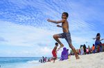 A group of children are playing on a beach.