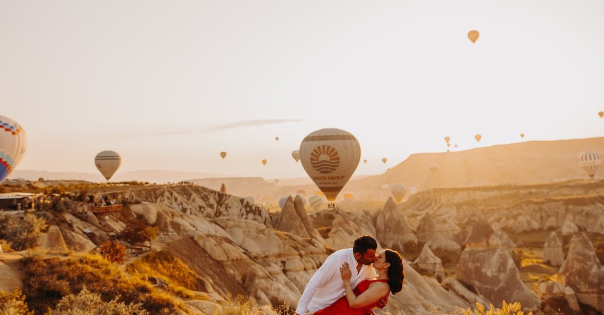 Happy couple kissing with scenic hot air balloon backdrop in Reno, symbolizing love found through matchmaking.