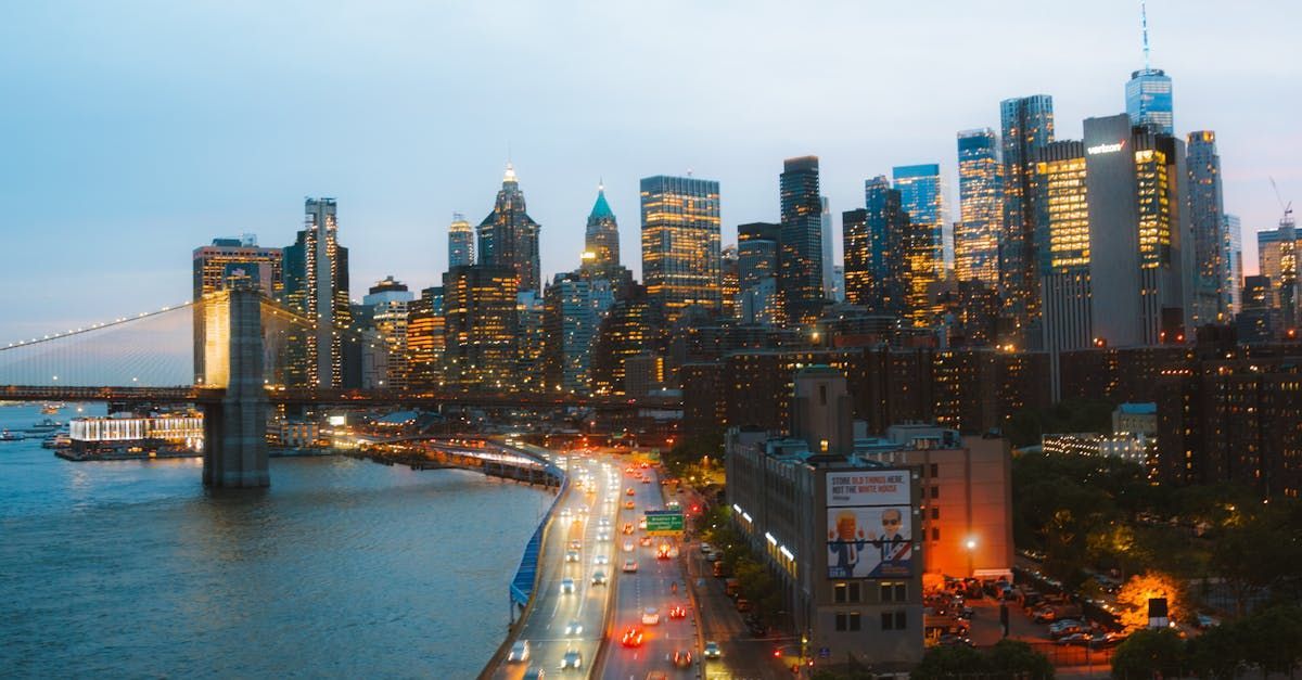 An aerial view of a city skyline at night with a bridge in the foreground.