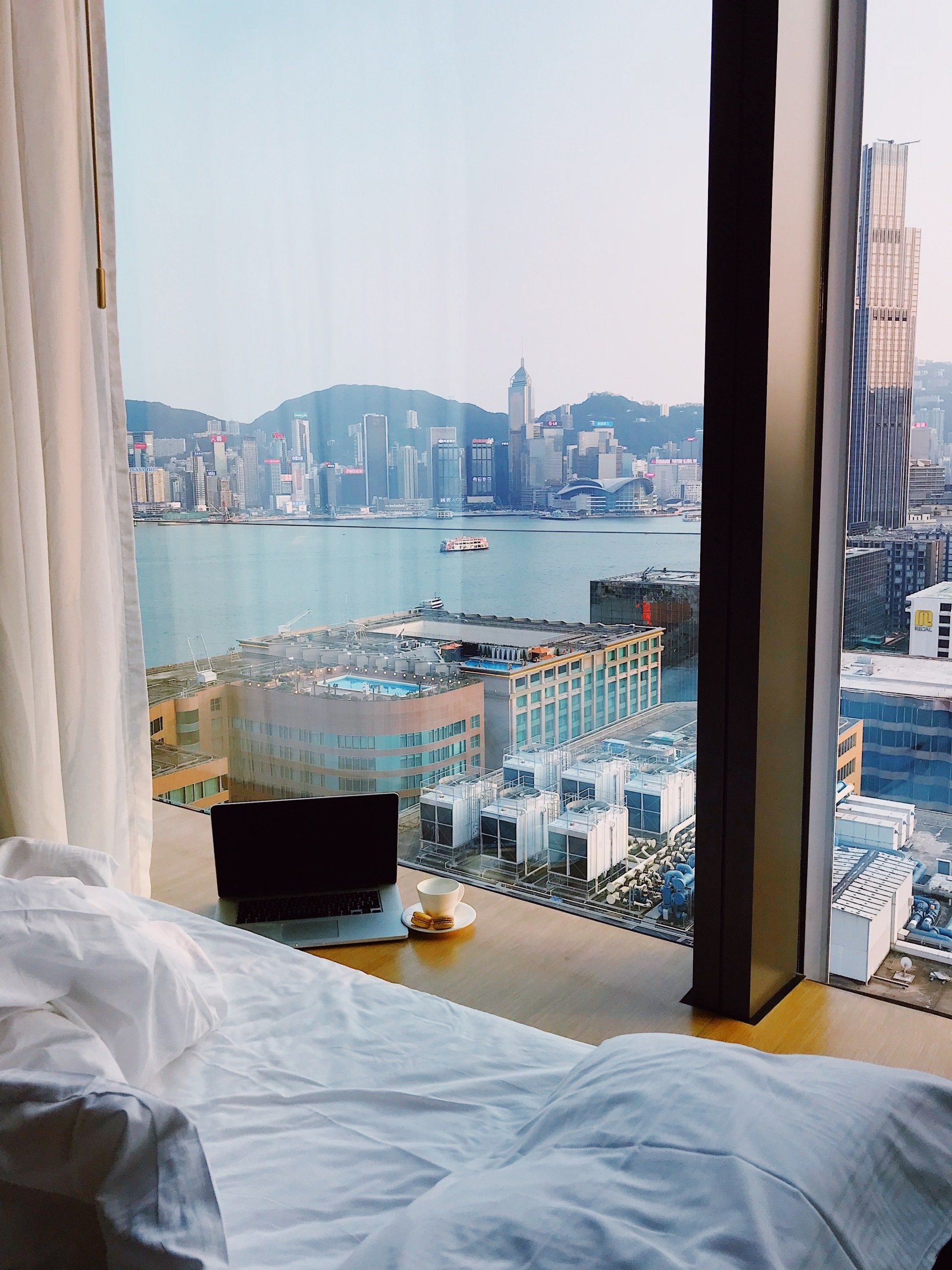 A hotel room with a view of the city and the ocean.