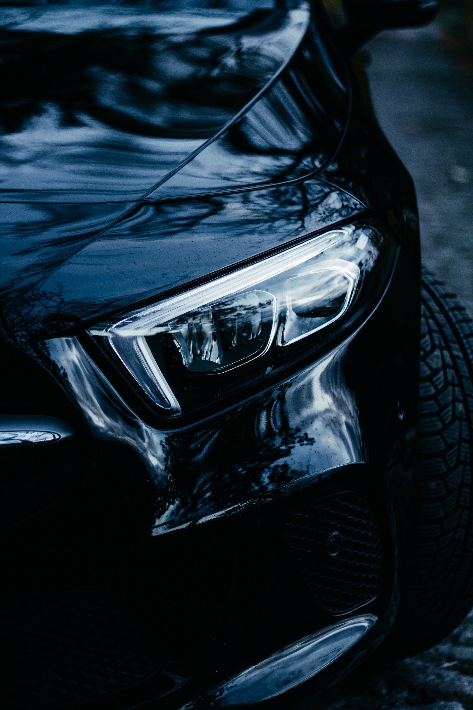 A close up of the headlight of a black car.