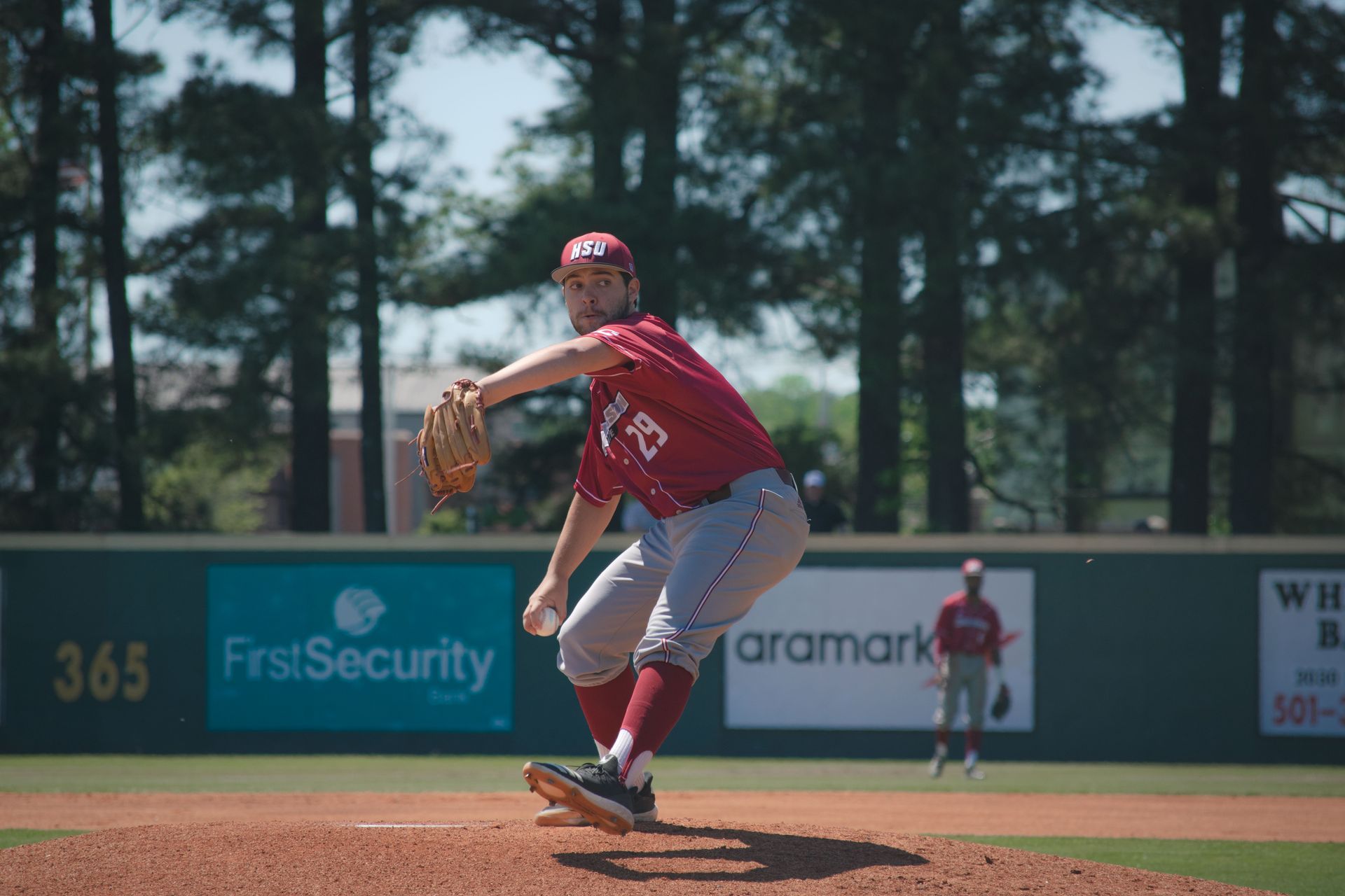 A baseball player is pitching a ball on a field.