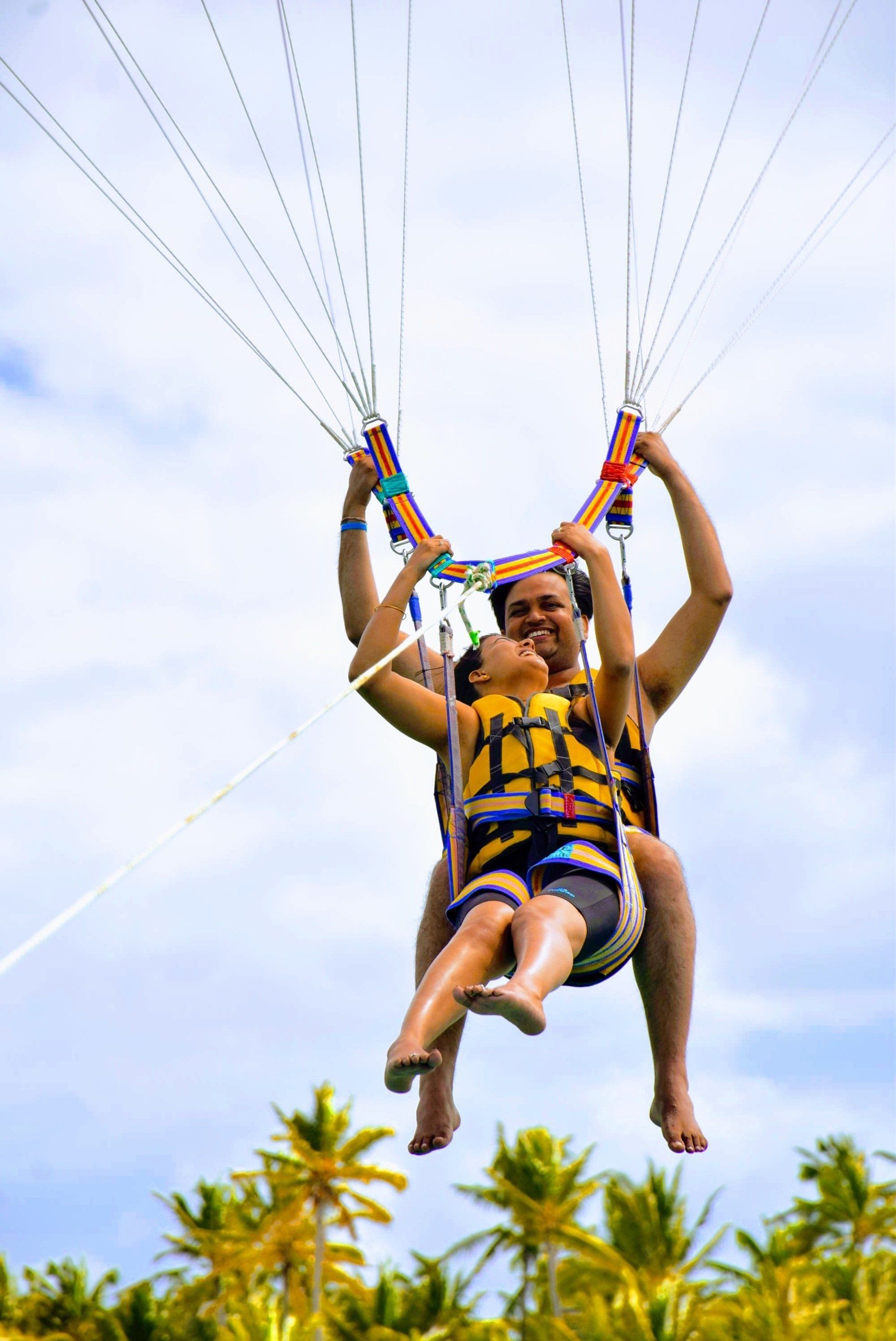 Bottom view of a two people riding on parasailing