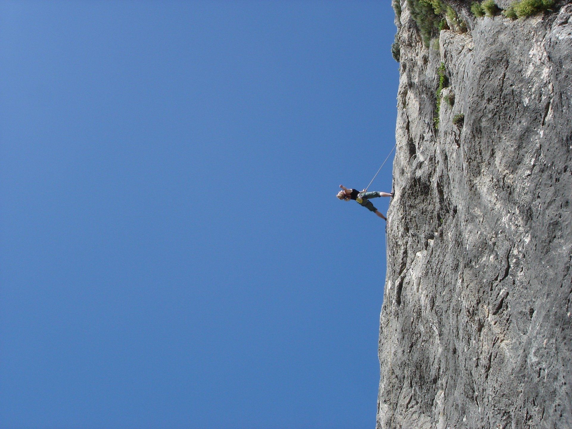 A person is climbing up the side of a cliff.