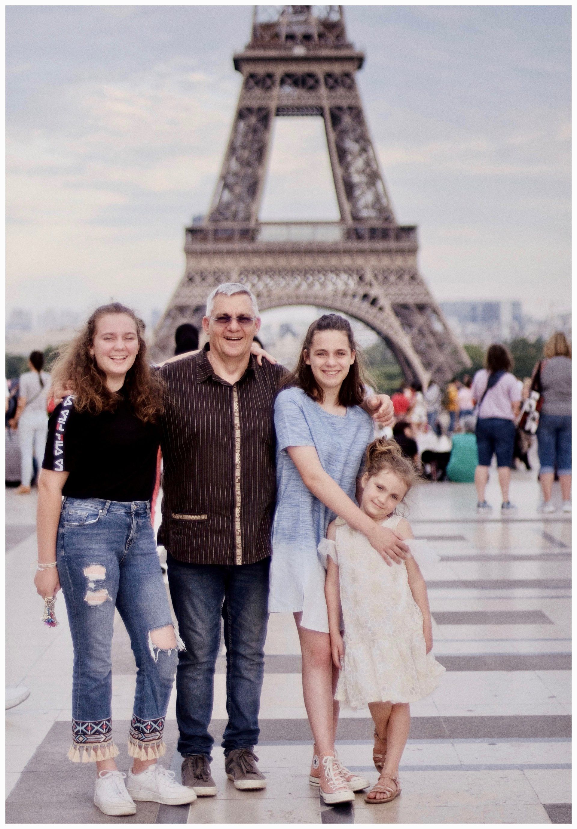 a family standing in front of the eiffel tower in paris