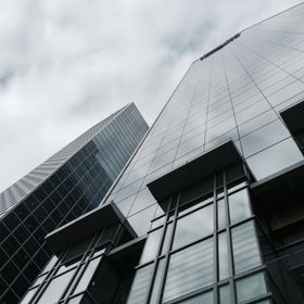 Looking up at a tall building with a cloudy sky in the background