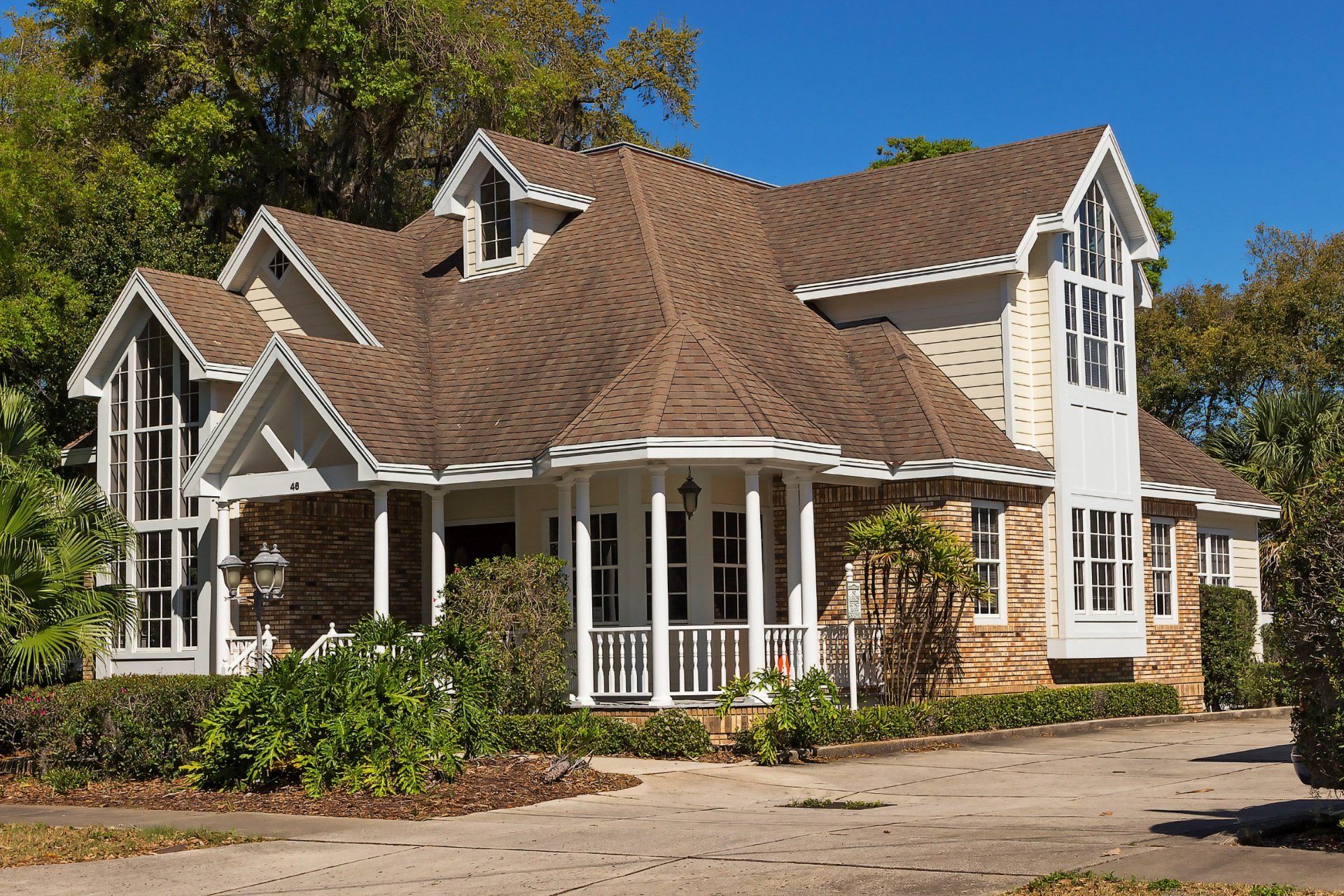 a brick house with a brown roof and white trim