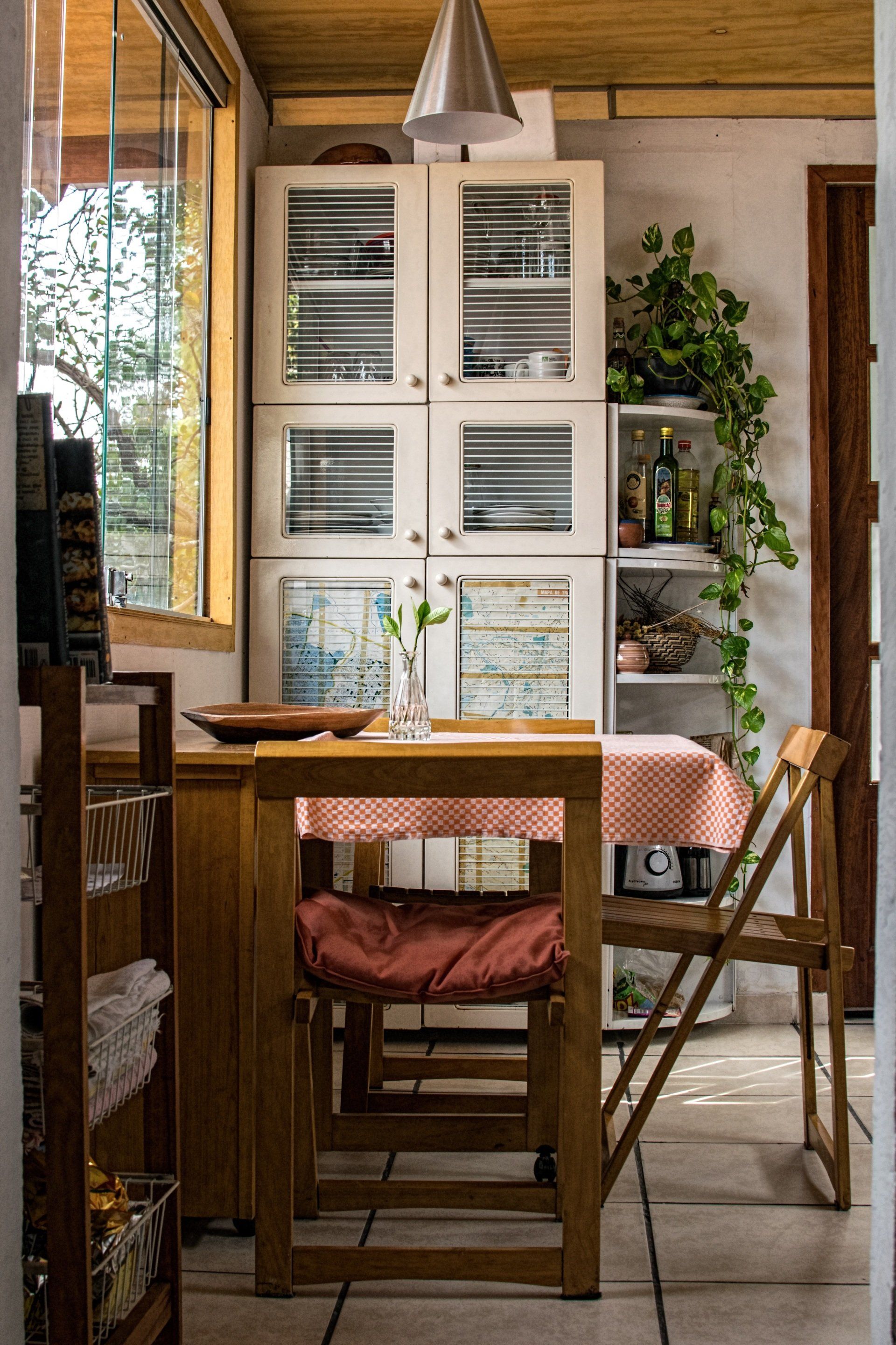 A dining room with a table and chairs and a glass cabinet.