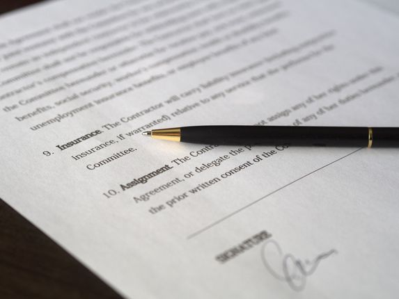 A pen is sitting on top of a signed document.