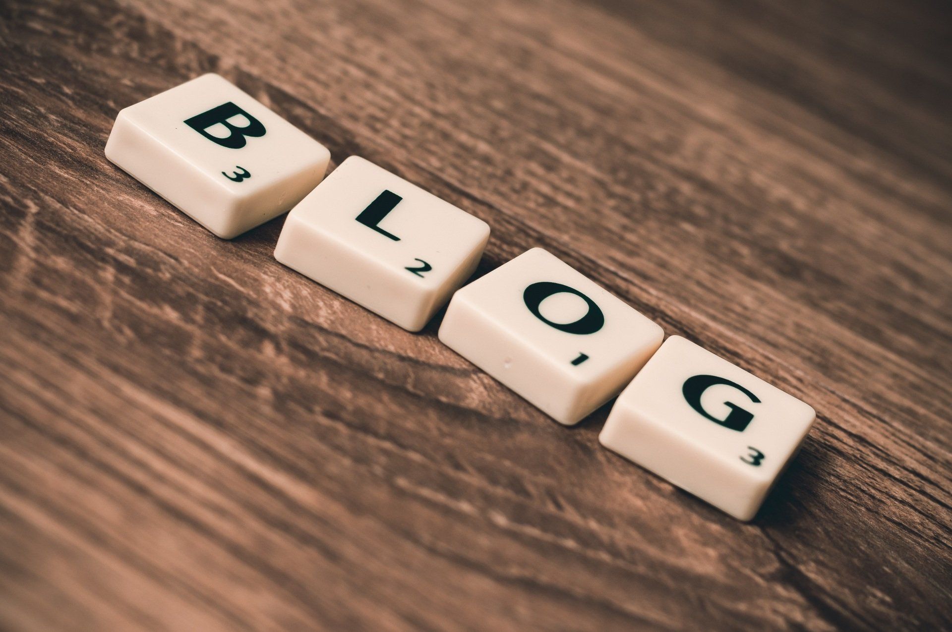 Scrabble tiles spelling out the word blog on a wooden table